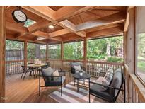 Inviting screened porch with wood flooring, comfortable seating, and views of the landscaped backyard at 5315 Mccormick Rd, Durham, NC 27713