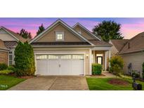 Charming home with a two-car garage, beautiful siding, manicured lawn, and inviting curb appeal at sunset at 575 Tomkins Loop, Cary, NC 27519