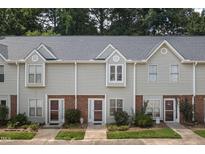 Charming townhome exterior with light gray siding, brick accents, and well-maintained landscaping at 6 Parsons Chase Ln, Durham, NC 27713