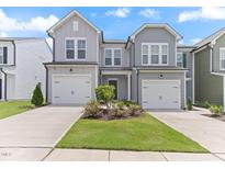 Well-maintained townhomes featuring attached garages, lush lawns, and inviting entrances at 706 Ambrose Hill Lane Ln, Wendell, NC 27591