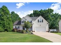 Charming two-story home with a well-manicured lawn, beautiful landscaping, and an attached two-car garage at 74 Fountain Dr, Clayton, NC 27520