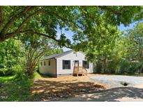 Charming single-story home with white siding, dark shutters, and a welcoming wooden porch at 810 Williams St, Burlington, NC 27217