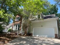Charming home featuring mixed brick and vinyl siding, attached garage and a well-maintained yard with mature trees at 8100 Laurel Mountain Rd, Raleigh, NC 27613