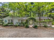 Charming home with an arched, vine-covered entrance and gravel drive at 914 Cindy St, Cary, NC 27511
