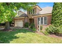Charming brick and stone home with lush landscaping, mature trees, and inviting front lawn at 107 Sonoma Valley Dr, Cary, NC 27518