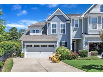 Charming two-story home featuring a two-car garage, a well-manicured lawn, and two chairs on the front porch at 108 Ribbon Walk Ln, Holly Springs, NC 27540