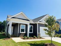Charming home with gray siding, white trim, brick accents, and a well-manicured lawn at 144 N Keatts Winner Ct, Wilson's Mills, NC 27520