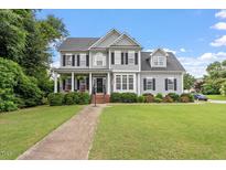 Charming two-story home features a well-manicured lawn, inviting front porch, and classic architectural details at 1505 Mclaurin Ln, Fuquay Varina, NC 27526