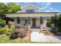 Charming home featuring a welcoming front porch with brick columns and beautiful landscaping at 200 W Corbin St, Hillsborough, NC 27278