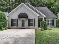 Charming one-story home featuring a well-manicured lawn and a striking black awning over the front door at 2109 Star Sapphire Dr, Raleigh, NC 27610