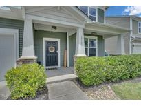 Charming front door with decorative wreath, welcome sign, and stone accents on a two-story home at 2123 Scarlet Sage Dr, Durham, NC 27704
