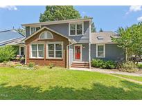 Charming two-story home with a well-manicured lawn, brick accent and inviting red front door at 2208 Pathway Dr, Chapel Hill, NC 27516