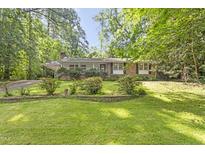 Charming brick home featuring a well-manicured lawn and mature trees, offering a serene and inviting curb appeal at 2406 Oxford Rd, Raleigh, NC 27608