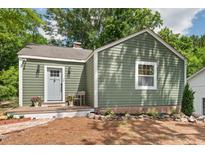 Charming home featuring a quaint porch, inviting gray front door, and pleasant green siding at 2410 Huron St, Durham, NC 27707