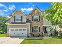 Charming two-story home featuring stone accents, a manicured lawn, and an attached two-car garage at 2605 Bloomsberry Ridge Dr, Fuquay Varina, NC 27526