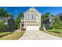 Inviting two-story home with a two-car garage, complemented by lush landscaping and a well-maintained lawn at 304 Garden Walk Dr, Durham, NC 27703