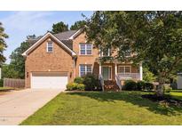 Charming brick two-story home with well-manicured lawn and inviting front porch at 406 Dairy Farm Dr, Hillsborough, NC 27278
