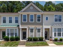 Charming townhome featuring two-story design, neat landscaping, and neutral exterior at 4536 Sugarbend Way, Raleigh, NC 27606