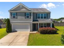 Two-story home with gray siding, complemented by a well-manicured front yard and a two car garage at 737 Botanical Ct, Bunnlevel, NC 28323