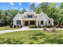 Charming white brick home with a well-manicured lawn, beautiful landscaping, and a welcoming entrance at 8420 Bells Lake Rd, Apex, NC 27539