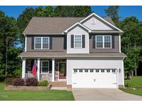 Charming two-story home featuring a manicured lawn, a two-car garage, and a welcoming front porch at 933 Weatherby Ln, Creedmoor, NC 27522
