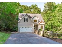 Charming home with a two-car garage, manicured landscaping, and an inviting driveway surrounded by mature trees at 105 Greenbriar Ct, Chapel Hill, NC 27516