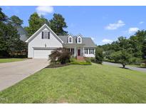 Charming single Gathering home with manicured lawn and inviting red door at 107 Roan Dr, Garner, NC 27529