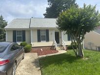 Charming home featuring a well-maintained lawn, walkway, landscaping, and neutral exterior paint at 1819 Collier Rd, Durham, NC 27707