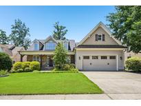 Charming home featuring stone accents, a well-manicured lawn, and a two-car garage at 204 Plantation Dr, Youngsville, NC 27596