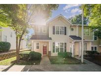 Charming townhome with a red door, well-maintained landscaping, and a sunny facade at 2261 Plum Frost Dr, Raleigh, NC 27603