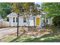 Charming single-story home featuring a bright yellow door, a brick pathway, and a well-manicured front yard at 2804 Barmettler St, Raleigh, NC 27607