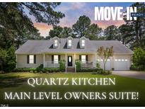 Charming one-story home with dormer windows, a two-car garage, a manicured lawn and inviting front porch at 3109 Gold Dust Ln, Willow Springs, NC 27592