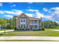 Charming brick home with a landscaped lawn, dark shutters, and a welcoming front porch at 326 S Parliament Way, Clayton, NC 27520