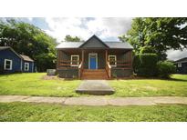 Charming home features a covered porch and a bright blue front door at 416 Everett St, Burlington, NC 27215