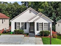 Charming single-story home featuring classic white siding, black shutters and mature landscaping at 4505 Woodlawn Dr, Raleigh, NC 27616