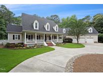 Charming home featuring a welcoming front porch, well-manicured lawn, and a spacious driveway leading to an attached garage at 5317 Moonflower Ct, Holly Springs, NC 27540
