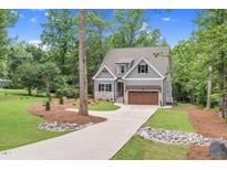 Charming two-story home with gray siding, stone accents, and a well-manicured front yard at 5504 Earle Road, Raleigh, NC 27606