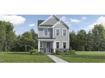 Charming two-story home featuring stone accents, gray siding, and lush landscaping, creating inviting curb appeal at 5545 Cayden Cove Dr, Wendell, NC 27591