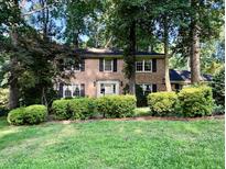 Charming brick home with a manicured lawn and mature trees providing shade at 5617 Partridge Ln, Raleigh, NC 27609