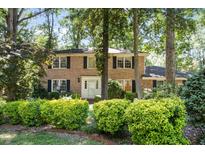 Charming two-story brick home with black shutters and a beautifully landscaped front yard at 5617 Partridge Ln, Raleigh, NC 27609
