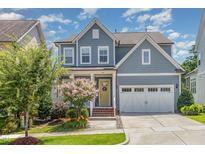 Charming two-story home with a welcoming front porch, attached two-car garage, and well-maintained landscaping at 664 Old Dairy Dr, Wake Forest, NC 27587