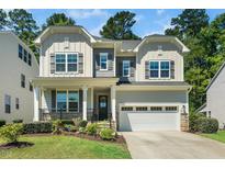 Charming two-story home with a well-manicured lawn, attached garage, and craftsman-style architectural details at 7301 Villoria Ln, Raleigh, NC 27617