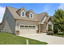 Charming home featuring stone accents, dormer windows, neutral siding, and a spacious driveway leading to an attached two-car garage at 80 Scarlet Bell Dr, Youngsville, NC 27596