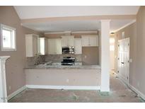 Bright kitchen featuring white cabinets, stainless steel appliances, and a granite countertop bar at 80 Scarlet Bell Dr, Youngsville, NC 27596