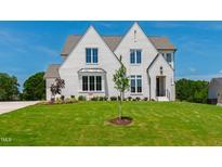 Stunning two-story home with a white brick exterior, manicured lawn, and professional landscaping at 808 Shiloh Hills Dr, Fuquay Varina, NC 27526