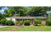Charming brick ranch home with mature landscaping and inviting covered front porch at 905 Aversboro Rd, Garner, NC 27529