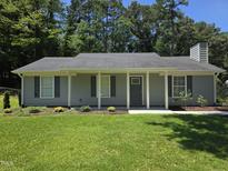 Charming single-story home with manicured lawn, inviting front porch, and light gray siding at 1016 Buckhorn Rd, Garner, NC 27529
