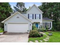 Charming two-story home with a blue front door and a beautifully landscaped front yard at 109 Crane Meadow Pl, Chapel Hill, NC 27514