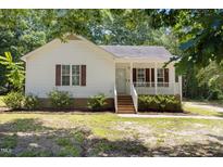 Charming one-story home featuring a cozy front porch and well-maintained landscaping at 119 Percheron Dr, Zebulon, NC 27597