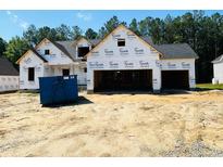 View of new construction home featuring a three-car garage and Tyvek HomeWrap at 128 Seahawk Way, Zebulon, NC 27597